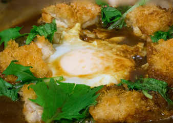 Fried chicken with egg in miso soup serve on hot stone bowl, japanese food. image for background, wallpaper and copy space