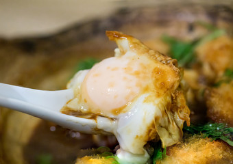 Fried chicken with egg in miso soup serve on hot stone bowl, japanese food. image for background, wallpaper and copy space