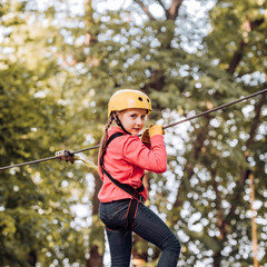 Rope way - little girl is looking at the rope slideway fearing. Early childhood development. Cute child girl.