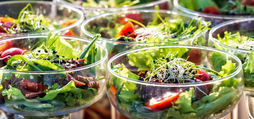 Green salat in a bowl on desk. Tomato, cheese and salad