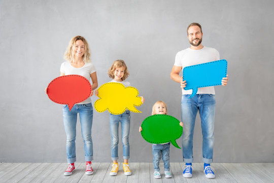Happy family holding colorful paper speech bubble blank