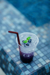 Fresh cold drink with blueberry and sweet soda, cold at the pool. Healthy beverage in a rustic style. Trendy lifestyle drink.