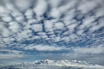 blue sky and clouds over winter mountains