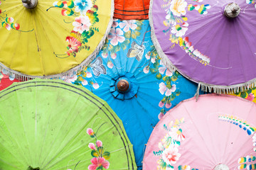 yellow up left green down left purple up right pink down right and blue in middle of traditional Thailand umbrella stock photo