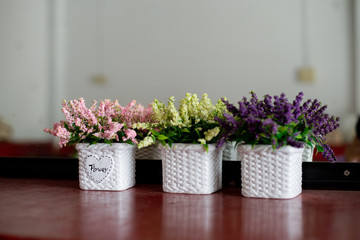 A bouquet of flowers in a vase on a wooden table, reflecting with a mirror