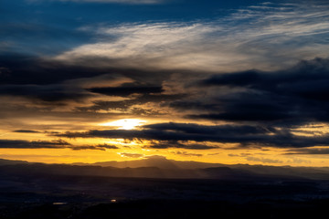 Fototapeta na wymiar Golden sunrise with rays through clouds across southern Utah