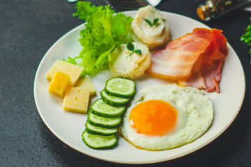 healthy food - breakfast (scrambled eggs, bacon, lettuce, asparagus, cucumbers, cheese, sandwich). food background. top view. copy space