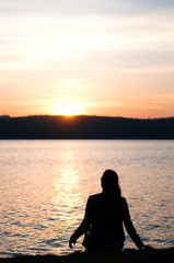 Naklejka na ściany i meble Lonely girl sitting alone moments sunset.