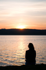 Lonely girl sitting alone moments sunset.