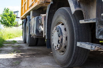 the wheels of the yellow dump truck standing in place