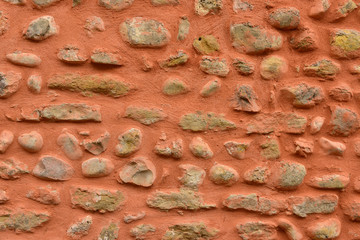 Mur de pierres et galets avec enduit rose