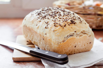 Homemade wheat bread with flax seeds on a kitchen table