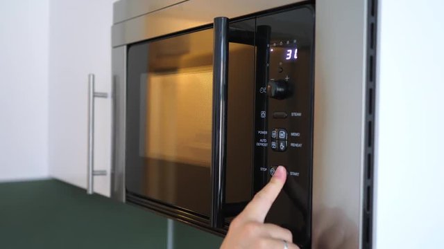 Hand Heating Ready-To-Cook Food In Microwave At Home.