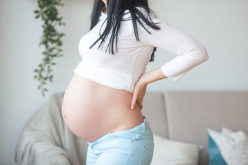 Pregnant woman having a backache. Expecting woman suffering from pain.