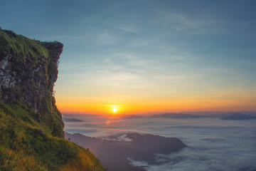 landscape sunrise nature of a great green mountain ridge, its tip is along the range behind the fog fog flying over at Phu chi fa,Chiang rai.