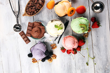 ice cream scoops of different colors and flavours with berries, nuts and fruits decoration on white background