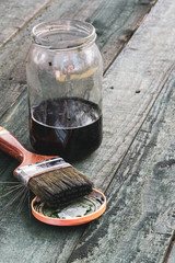 Fototapeta na wymiar Brush and jar of paint on wooden board