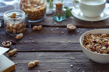 Healthy lifestyle breakfast background, granola bowl food and cashew nuts seed on brown wooden table with copy space, book cereal organic muesli morning diet oat meal for health, close up view