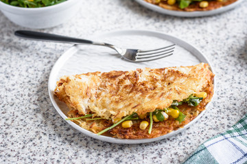 Potato rosti with corn and rocket salad served on a gray background. Traditional swiss dish