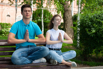 beautiful young couple sitting on a bench in the park