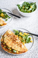 Potato rosti with corn and rocket salad served on a gray background. Traditional swiss dish