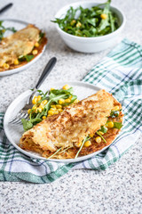 Potato rosti with corn and rocket salad served on a gray background. Traditional swiss dish