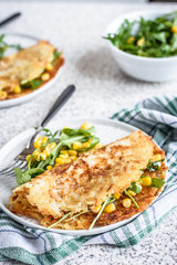 Potato rosti with corn and rocket salad served on a gray background. Traditional swiss dish