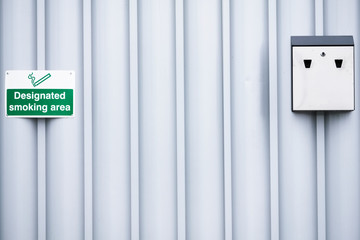 Designated smoking area sign and ash tray at office place of work