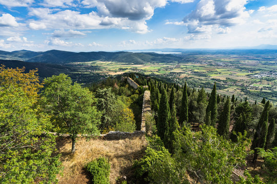 The Girifalco fortress on the hilltop overlooking Cortona offers a scenic view on Tuscan countryside and Trasimeno lake in the background, Italy