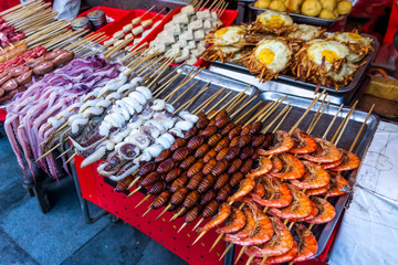 Roasted and raw insects, silkworms, scorpions, bugs, snakes, dog meat, octopus on stick