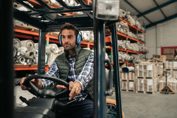 Fototapeta na wymiar Forklift driver working on the floor of a warehouse