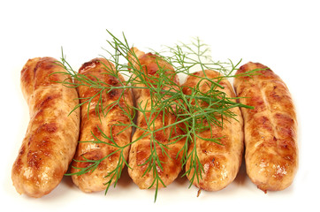 Meat sausages with glitter on a light background. Fried sausage. The concept of traditional cuisine.Sausage with greens