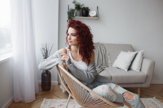 Closeup portrait of young beautiful redhaired woman. Redhead female indoors. Beauty portrait of attractive lady at home with free space.