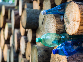 Plastic bottles stuck in wood logs. Ecology, recycling and plastic pollution concept.