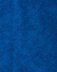 The texture of the fabric is blue terry towel. Terry cloth as a background.