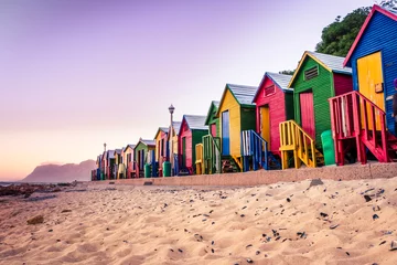 Fototapeten Lila Blick auf den wunderschönen Sonnenuntergang über der False Bay von Kalkbay mit kleinen bunten Häusern am Strand, mit Bergen im Hintergrund, Kapstadt, Südafrika  © Ava Peattie