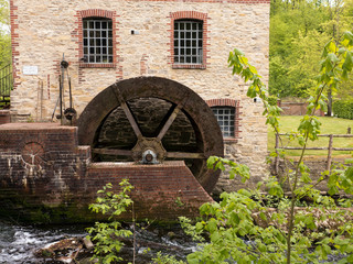 Das Mühlrad einer alten Wassermühle an einem fließenden Bach bei Osnabrück.