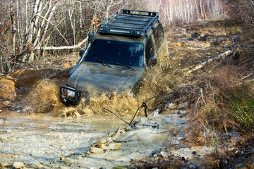 Extreme weekends. A car during a tough off-road competition diving in a muddy pool. Driver competing. © Volodymyr