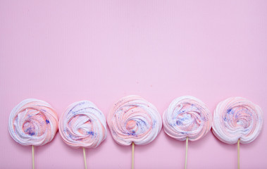 Pink meringues with glitter on a pink background