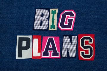 BIG PLANS text word collage, multi colored fabric on blue denim, planning and innovation concept, horizontal aspect