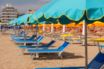 Sun umbrellas, sun beds, beach, Rimini, Italy.