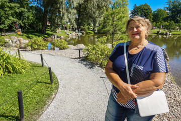 Obraz premium Old woman resting in the city Park