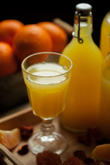 orange juice in bottles and a glass with fresh oranges, jam, on the table