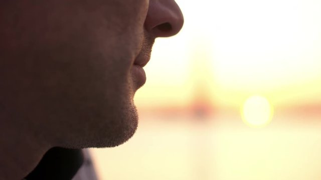 Portrait of attractive 40s man looking at the sunset. Close-up chin. Slow motion.