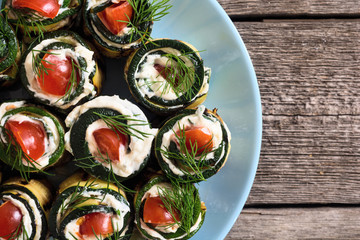 Zucchini rolls with cream cheese , tomatoes and dill