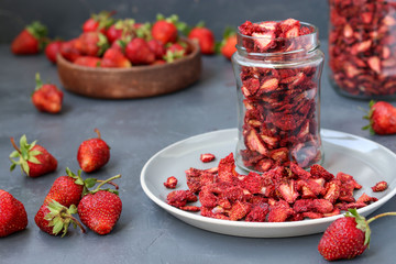 Strawberry chips are in a glass jar on a dark background, healthy food