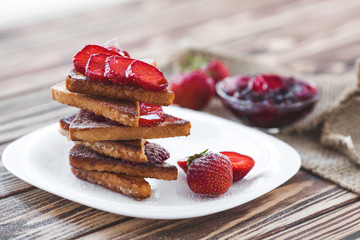 Morning breakfast. Toasts with strawberry and jam. Bread and confiture. Fresh hot toasts with cream. Delicious homemade dessert.