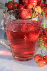 Cherry juice and cherries with drops on a wet table, selective focus, summer cool drink and tasty summer sweet cherry close up