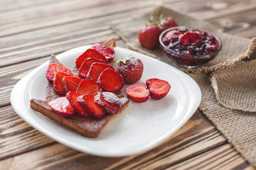 Morning breakfast. Toasts with strawberry and jam. Bread and confiture. Fresh hot toasts with cream. Delicious homemade dessert.