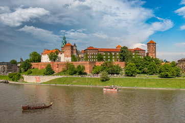 Fototapeta premium Wawel Castle and Wawel cathedral in the sun over the Vistula river on cloudy afternoon